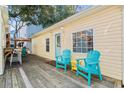 Relaxing deck with teal chairs and yellow table, adjacent to the home at 6001 - D07 S Kings Hwy., Myrtle Beach, SC 29575