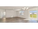 Bright living room with wood-look floors, sliding glass door and modern chandelier at 1106 Barrington Way, Conway, SC 29526