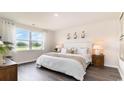 Spacious main bedroom with a white duvet, wood nightstands, and large window at 179 Calm Dr., Little River, SC 29566