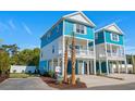 Blue and white two-story coastal home with a covered garage and a quaint balcony at 2302 Seaseeker Ln., Myrtle Beach, SC 29577