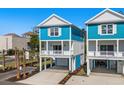 Bright blue two-story house with a covered garage and white pillars supporting a balcony at 2302 Seaseeker Ln., Myrtle Beach, SC 29577