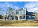 Two-story farmhouse with gray siding, white trim, and a wraparound porch at 3480 Highway 348, Loris, SC 29569