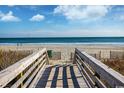 Wooden boardwalk leads to sandy beach with ocean view at 6804 N Ocean Blvd. # 1009, Myrtle Beach, SC 29572