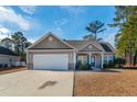 Tan house with a blue door and a two-car garage at 363 Long Meadow Dr., Loris, SC 29569