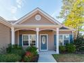 Front entrance with a covered porch and blue door at 363 Long Meadow Dr., Loris, SC 29569