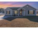 Charming single-story home with a well-maintained lawn and inviting entryway at sunset at 1049 Augustus Dr., Conway, SC 29527