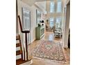 Bright foyer with hardwood floors, a staircase, and a view of the living room's tall windows at 118 Oatland Lake Rd., Pawleys Island, SC 29585