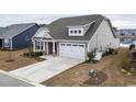 Tan house with a gray roof, two-car garage, and manicured lawn at 1262 Witch Hazel Way, Longs, SC 29568