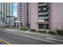 Ground level entrance to Palms building, showing parking and landscaping at 2406 N Ocean Blvd. # 604, Myrtle Beach, SC 29577