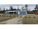 Charming single-story home with metal roof, covered porch, two-car garage, and gravel driveway at 445 W Willow Pond Rd., Johnsonville, SC 29555