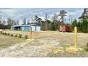 Expansive yard featuring a home, detached two-car garage, shipping container, and chained wooden posts at 445 W Willow Pond Rd., Johnsonville, SC 29555