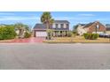 Two-story house with a red driveway, palm trees, and landscaping at 5096 Capulet Circle, Myrtle Beach, SC 29588