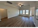 Bright living room with wood-look floors, a tray ceiling, and ample natural light from windows at 541 Honeyhill Loop, Conway, SC 29526