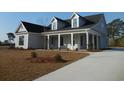 Beautifully landscaped single-Gathering home with a concrete driveway and a welcoming front porch with white columns at 2220 Pettus Way, Surfside Beach, SC 29575