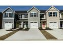 Row of new construction townhomes shows colorful doors, shutters, and one-car garages at 288 Myrtle Meadows Dr # 505E, Conway, SC 29526