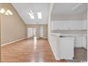 Open-concept living room and kitchen features vaulted ceilings, skylights, and modern fixtures at 4672 Lightkeepers Way # 50-E, Little River, SC 29566
