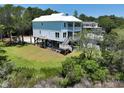 Lovely coastal home featuring expansive green space and a stylish stilt foundation, perfect for outdoor living at 48 Furman Ln., Pawleys Island, SC 29585