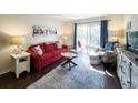 Cozy living room featuring a red couch, comfy armchair, and access to a balcony at 178 Salt Marsh Circle # 30-E, Pawleys Island, SC 29585
