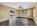 Bright living room with dark laminate flooring, large windows, and sliding glass doors at 1900 Shell Ct., Surfside Beach, SC 29575