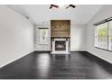 Bright living room boasts a modern fireplace feature wall and dark wood-look floors at 1900 Shell Ct., Surfside Beach, SC 29575