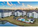 Beautiful aerial view showcasing the condo building, pool, and surrounding green spaces with a pond at 2060 Cross Gate Blvd. # 204, Surfside Beach, SC 29575