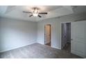 Bedroom featuring a tray ceiling with fan, carpet flooring, and doorway to closet at 399 Lifestyle Court, Surfside Beach, SC 29575