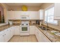 Well-equipped kitchen featuring white cabinets, granite countertops, and modern appliances at 5801 Oyster Catcher Dr. # 1624, North Myrtle Beach, SC 29582