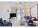 Bright living room featuring a ceiling fan, neutral carpet, and sliding glass doors to a patio at 820 Fairway Dr. # 1605, Longs, SC 29568