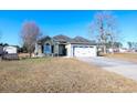 Exterior view of a lovely house with a garage and well-maintained lawn at 130 Lions Paw Ct., Loris, SC 29569