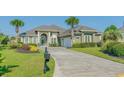 Green house with palm trees and a long driveway at 2000 Hideaway Point, Myrtle Beach, SC 29579