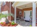Inviting front porch with tiled flooring, seating, and lush landscaping at 234 Sugar Mill Loop, Myrtle Beach, SC 29588