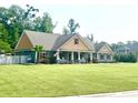 Inviting single-story home with a lush green lawn, front porch, and American flag displayed at 640 Fox Hollow Rd., Murrells Inlet, SC 29576