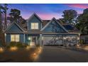 Stunning two-story home, illuminated at night, featuring blue siding and a three-car garage at 816 17Th Ave. N, Surfside Beach, SC 29575