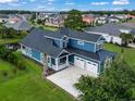 Blue house with a two-car garage and a pond nearby at 1103 Bluffton Ct., Myrtle Beach, SC 29579