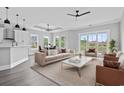 Open concept living room with large windows, modern furniture, and access to a kitchen at 1103 Bluffton Ct., Myrtle Beach, SC 29579