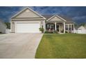 Traditional single-Gathering home with a two-car garage, green lawn and manicured flower bed at 141 Baylee Circle, Galivants Ferry, SC 29544