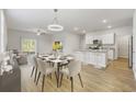 Open concept kitchen and dining area with white cabinets and an island at 219 Marauder Dr., Longs, SC 29568