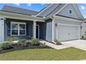 Gray and blue house exterior with landscaping and white garage door at 260 Red Maple Loop, Longs, SC 29568