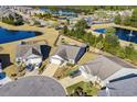 Panoramic aerial view shows the neighborhood featuring mature trees, a large pond, and community amenities at 3716 Mackevans Ct., Myrtle Beach, SC 29579