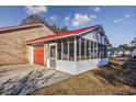 White screened porch attached to brick home with red metal roof at 602 Luttie Rd., Myrtle Beach, SC 29588