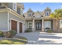 Close-up view of a home's front entrance featuring stone accents, a covered porch, and a three-car garage at 1422 Bohicket Ct., Myrtle Beach, SC 29579