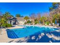 Community swimming pool with lounge chairs and umbrellas at 2450 Marsh Glen Dr. # 821, North Myrtle Beach, SC 29582