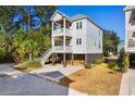 Two-story house, white exterior, and a spacious driveway at 34 Lazy Hammock Trail, Pawleys Island, SC 29585