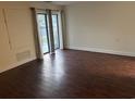 Spacious living room with dark wood flooring and sliding glass doors at 5001 Little River Rd. # E-110, Myrtle Beach, SC 29577