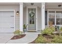 Close-up of front door with decorative wreath, sidelights, and craftsman details at 104 Grace Bay Ct., Pawleys Island, SC 29585