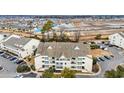 An aerial view of the condo building in a developing community near a pond at 1100 Possum Trot Rd. # E-238, North Myrtle Beach, SC 29582
