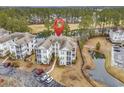 Aerial view of condo building with a pond and golf course in the background at 242 Sun Colony Blvd. # 303, Longs, SC 29568