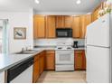 Galley style kitchen featuring wood cabinets and white appliances at 4533 Girvan Dr. # D, Myrtle Beach, SC 29579