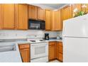 Cozy kitchen with wood cabinets, white appliances, and a breakfast bar at 4533 Girvan Dr. # D, Myrtle Beach, SC 29579