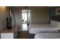 Two twin beds, dresser, TV, and view into living area at 2000 N Ocean Blvd. # 1206, Myrtle Beach, SC 29577